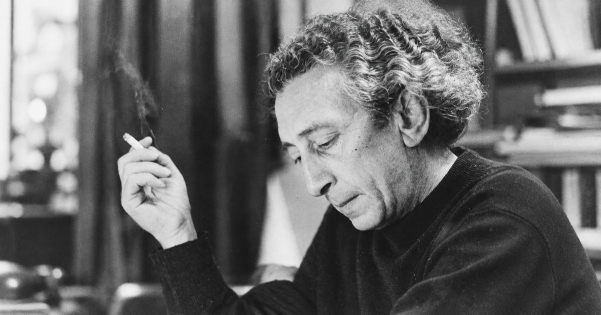 Abba Kovner avec une cigarette en main assis a son bureau.