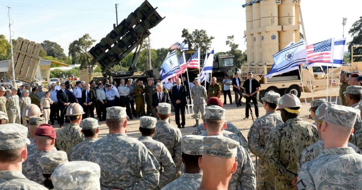 Cérémonie militaire dans une base du Néguev réunissant des soldats israéliens et américains devant des systèmes de défense antimissile et des drapeaux des deux pays.