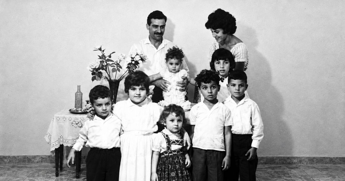 Portrait de famille ancien en noir et blanc attribué à Eli Cohen, avec son épouse Nadia et plusieurs enfants réunis dans un intérieur familial.