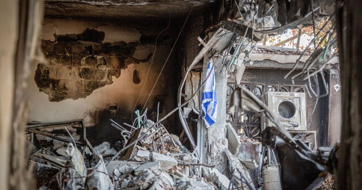 Intérieur d'une maison détruite dans un kibboutz en Israël avec un drapeau israélien.