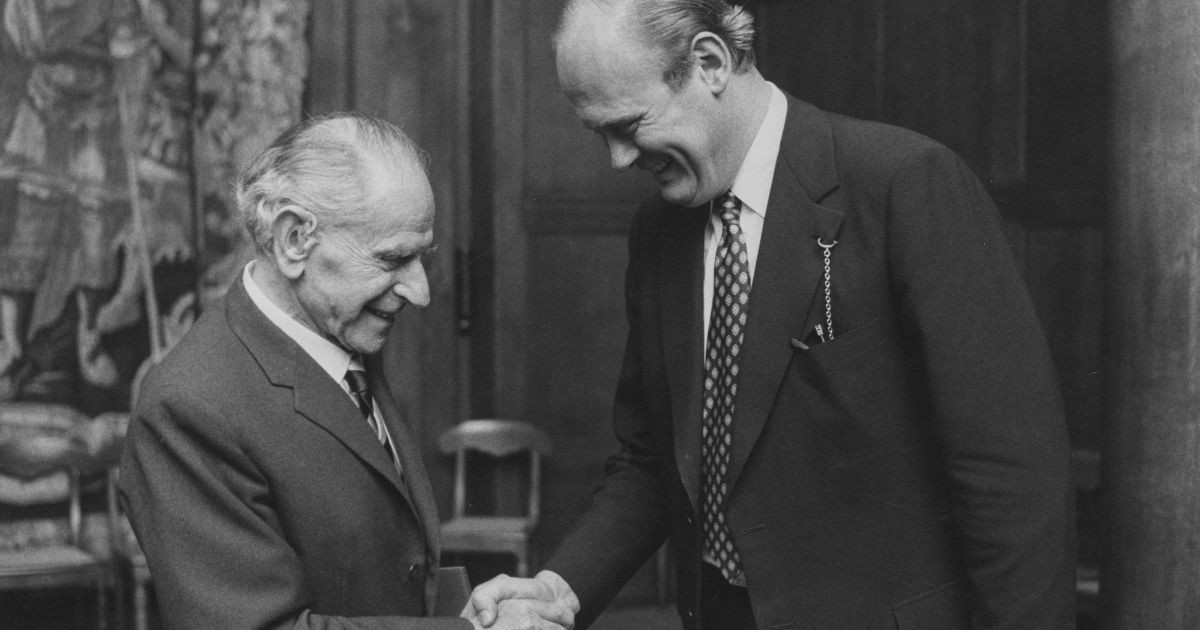 Karl Popper serrant la main d'un collègue lors d'une cérémonie.