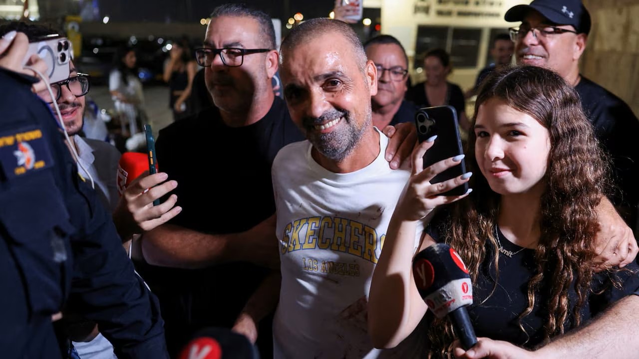 Yaniv Hayun souriant, entouré de journalistes et de personnes venues l’accueillir à l’aéroport Ben Gourion.