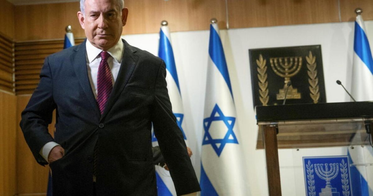 Le Premier ministre israélien Benjamin Netanyahu, l'air grave, devant des drapeaux d'Israël avant une déclaration sur l'Iran