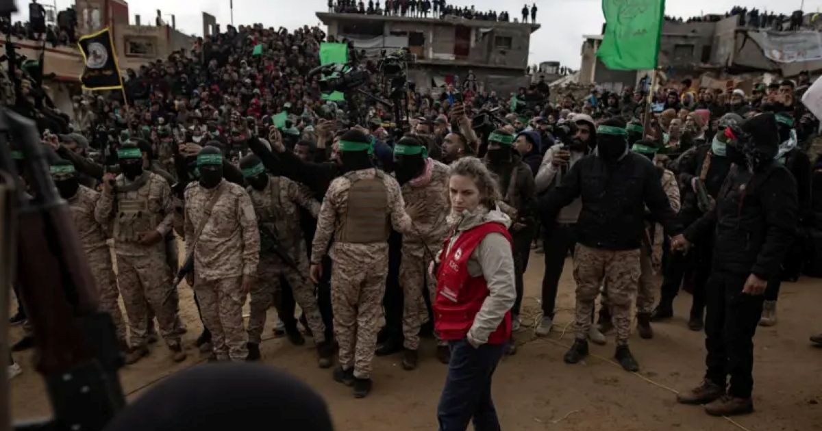 Une représentante de la Croix-Rouge se tient aux côtés de combattants du Hamas.