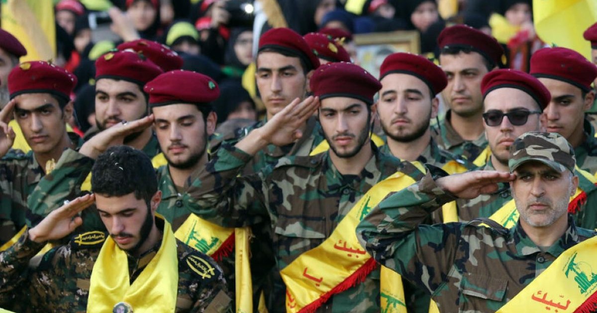 Rassemblement de combattants en uniforme militaire et bérets rouges effectuant un salut militaire