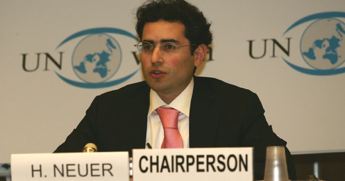 Hillel Neuer en tant que Chairperson lors d'une conférence avec les logos de l'ONU en arrière plan