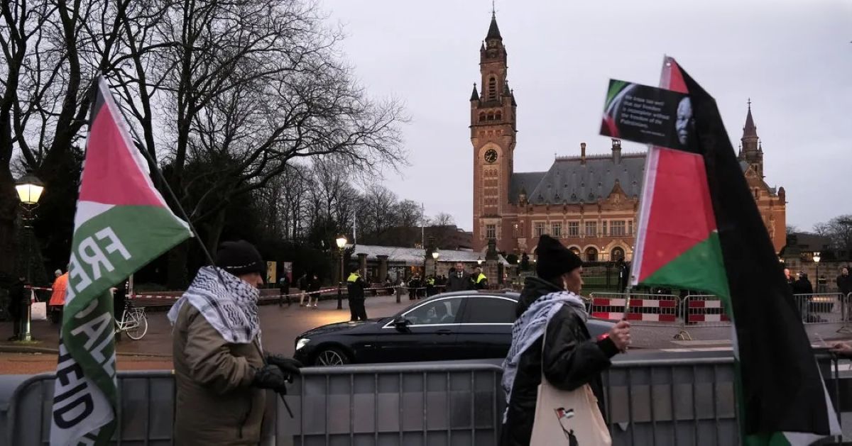 Des manifestants brandissant le drapeau palestinien marchent devant la Cour internationale de justice à La Haye
