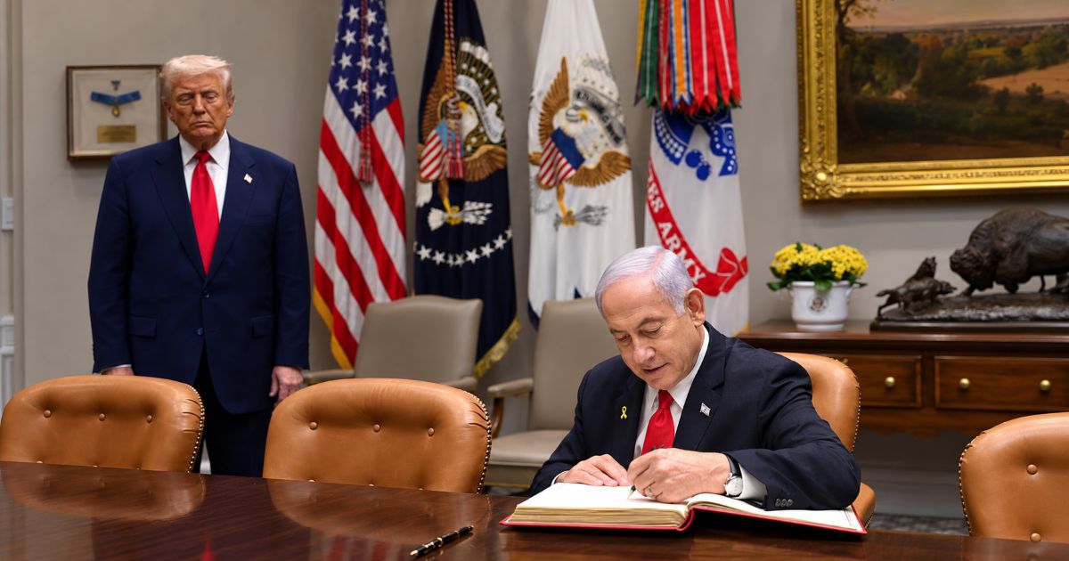 Benjamin Netanyahou signe le livre d’or à la Maison-Blanche, à Washington, le 7 avril 2025, sous le regard du président américain Donald Trump.