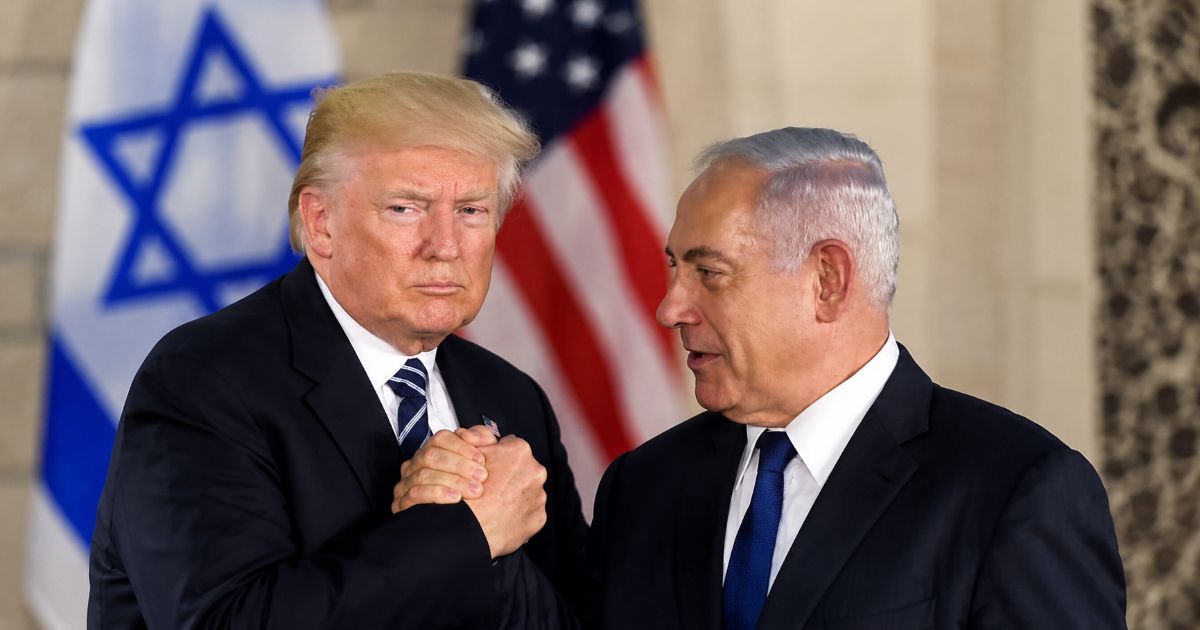 Donald Trump et Benjamin Netanyahou échangent une poignée de main à Jérusalem, devant les drapeaux d’Israël et des États-Unis.