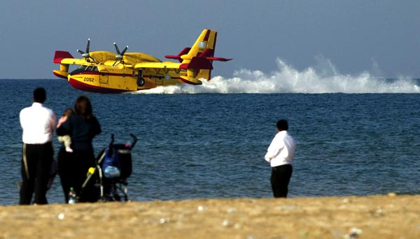 Les Canadairs se ravitaillant à la surface de la méditerranée sous l'oeil hagard des curieux